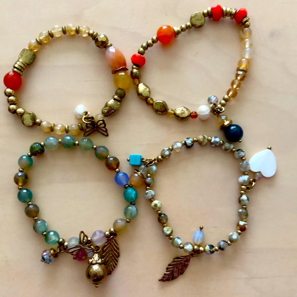 Beaded bracelets with charms , worn together or alone . Various colors
